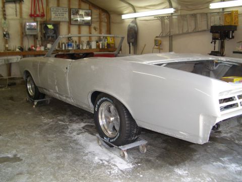 1967 Pontiac GTO - A 1967 Pontiac GTO convertible is undergoing restoration in a garage, resting on dollies.