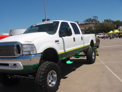 1986 Ford Bronco - A heavily modified pickup truck is parked outdoors under a clear blue sky.