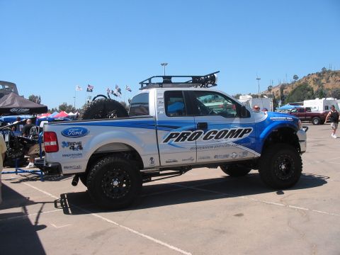 1986 Ford Bronco - A lifted Ford pickup truck with custom graphics and off-road accessories is parked outdoors.