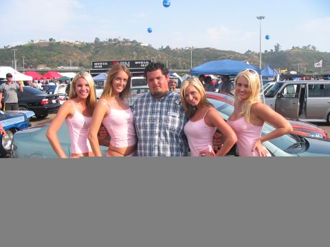 1986 Ford Bronco - A group poses for a photo at an outdoor car event with several vehicles visible in the background.