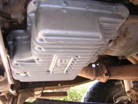 1984 Ford Bronco - Close-up of a deep transmission pan with cooling fins, likely an aftermarket part.