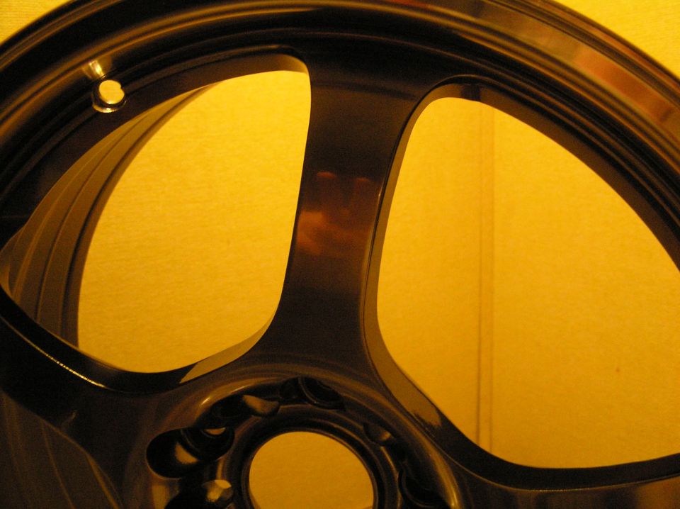 Close-up of spoke and outer lip of a dark alloy wheel under warm light