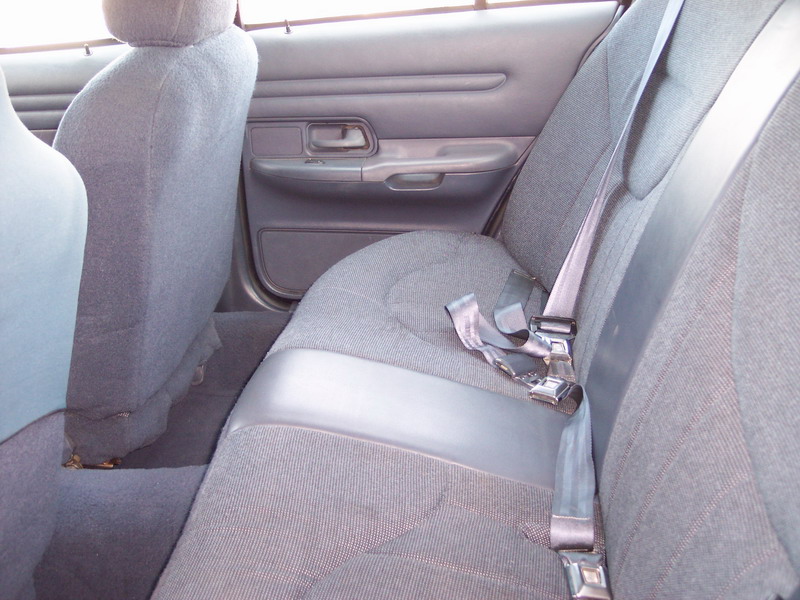 Gray cloth rear bench seat and door panel inside a sedan