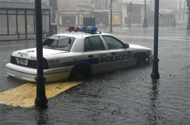 2000 Isuzu Rodeo - A police car is seen driving through flooded streets during a heavy downpour.