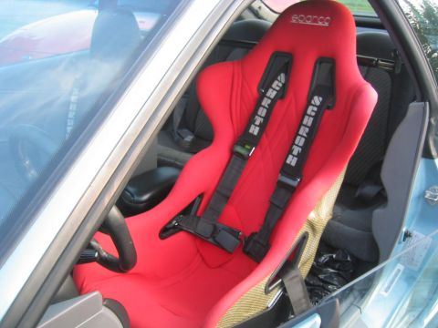 1993 Ford Probe - Interior view of a car's red racing seat with multi-point harnesses and a Sparco logo.