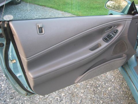 1993 Ford Probe - Interior view of a car's driver side door panel, showing the armrest and window controls.