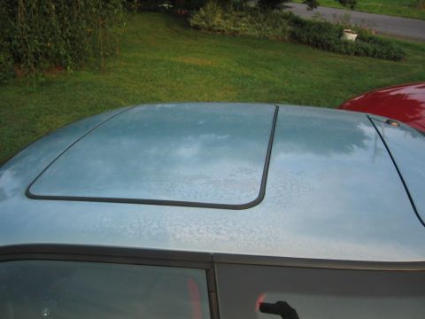 1993 Ford Probe - The roof of a light blue car with a sunroof is visible, with a red car partially seen in the background.