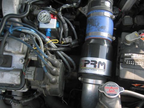 1993 Ford Probe - Close-up of an engine bay showing an aftermarket PRM intake system and a pressure gauge.