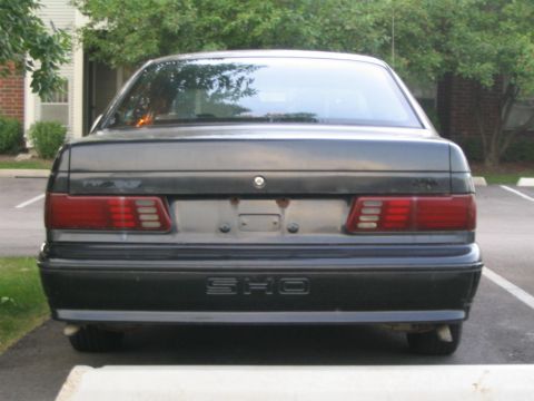1990 Ford Taurus - Rear view of a dark sedan with SHO badging visible on the lower bumper.