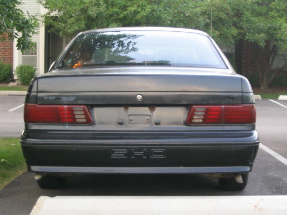 Rear view of a gray Ford Taurus SHO showing the SHO badge on the lower bumper