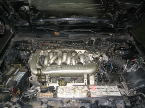 1990 Ford Taurus - The engine compartment of a 1990 Ford Taurus SHO is visible, with the V6 engine and associated components clearly displayed.