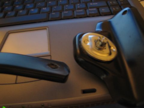 1990 Ford Bronco - disassembled black plastic key fob and detached key blade lie on a laptop's touchpad and keyboard.