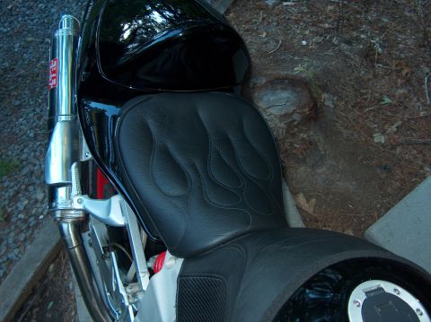 2002 Suzuki TL1000R - A black motorcycle seat with flame stitching is visible next to a Yoshimura exhaust pipe.