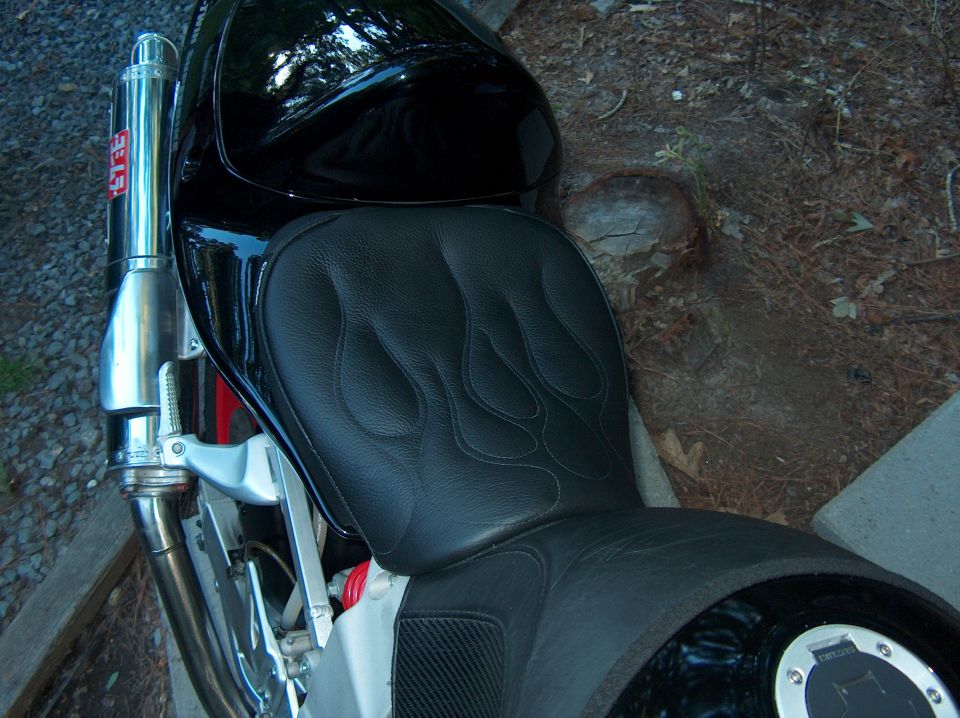 Black motorcycle seat with flame stitching and Yoshimura exhaust pipe
