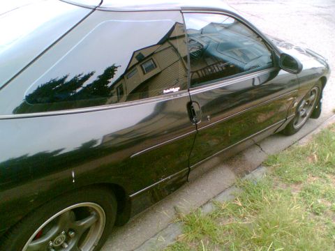 1997 Ford Probe - Side view of a black 1997 Ford Probe parked on the side of the road.