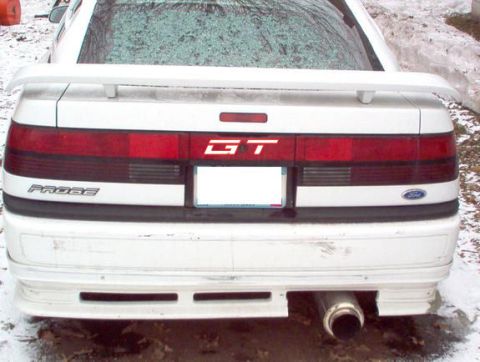 1996 Ford Probe - The rear of a white Ford Probe GT shows a full-width taillight bar and a spoiler.