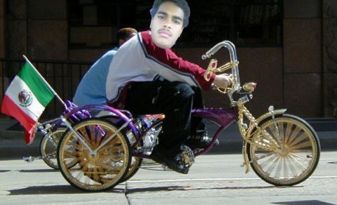 2000 Isuzu Rodeo - A person rides a custom lowrider tricycle decorated with a Mexican flag.
