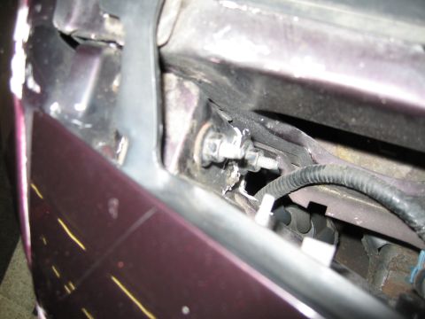1992 Ford Crown Victoria - Damage to the front fender area of a 1992 Ford Crown Victoria reveals exposed wiring and mounting hardware.
