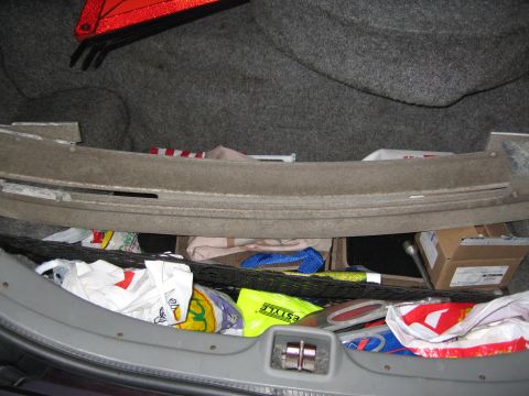 1992 Ford Crown Victoria - Contents of a car's trunk, including a safety triangle and various bags.