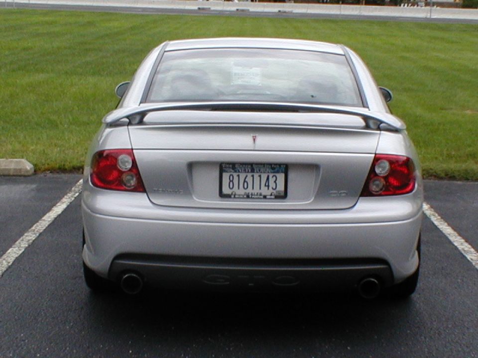 Silver sedan rear view, with spoiler and New York license plate