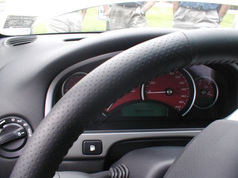 1979 Ford Bronco - The interior of a car is shown, focusing on the steering wheel and instrument cluster with red accents.