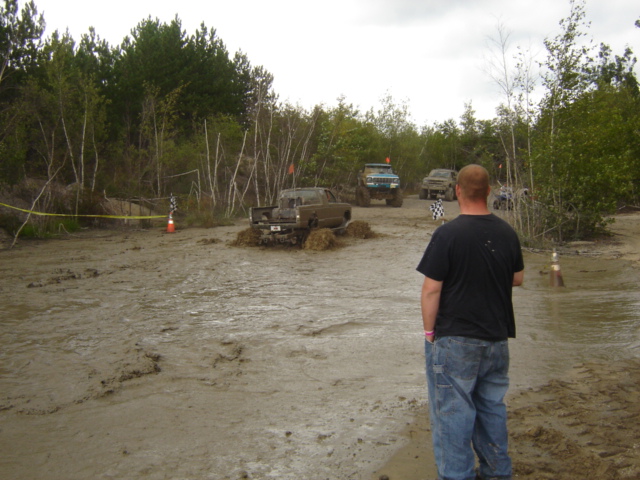 1987 Suzuki Samurai stuck in mud pit with other off-road vehicles nearby