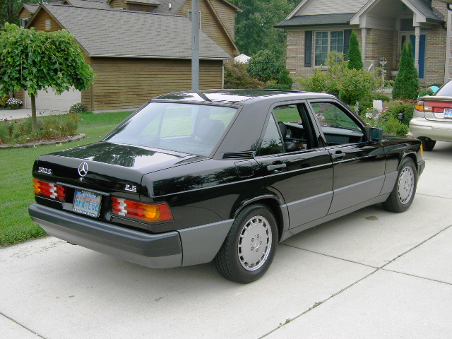Black Mercedes-Benz 190E sedan rear three-quarter view in driveway