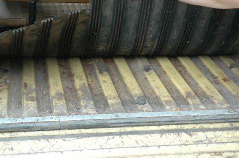 1972 Ford Bronco - Close-up of a vehicle's interior floor, showing corrugated metal and a rubber mat.