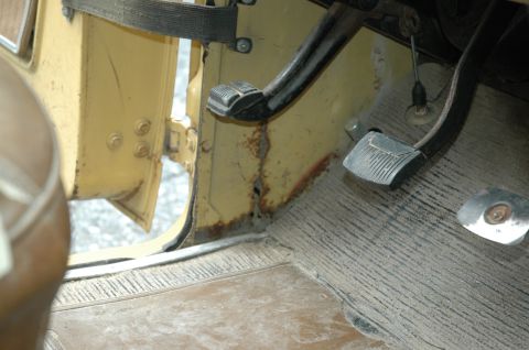 1972 Ford Bronco - Interior view of a 1972 Ford Bronco, highlighting the driver's side pedals and rusted door jamb.