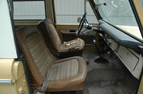 1972 Ford Bronco - Interior view of a 1972 Ford Bronco, showing worn tan seats and dashboard details.