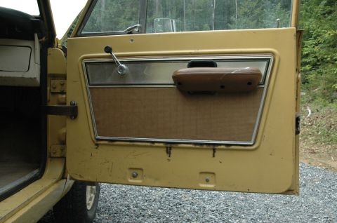 1972 Ford Bronco - Close-up of a vehicle's interior door panel, revealing its aged materials and functional components.