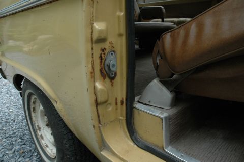 1972 Ford Bronco - Close-up view of a vehicle's interior door jamb and seat, showing signs of wear and rust.