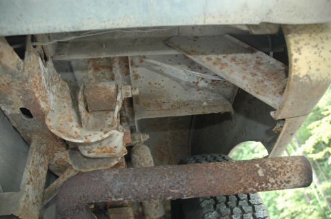 1972 Ford Bronco - Close-up of a rusty vehicle's undercarriage, revealing suspension parts and an exhaust pipe.