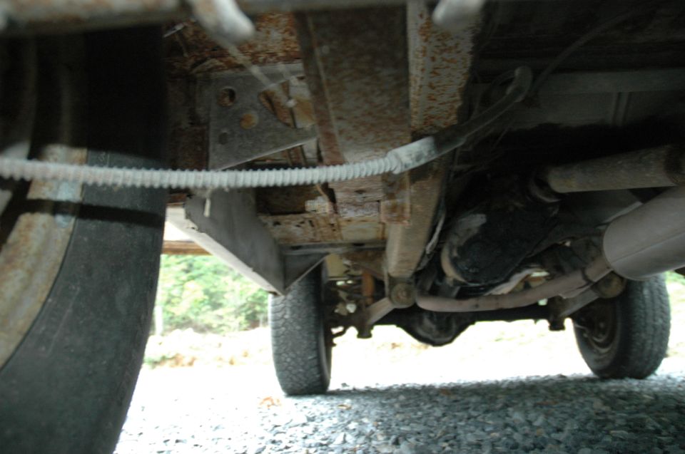 Underside view of a vehicle showing suspension, exhaust pipe, and differential