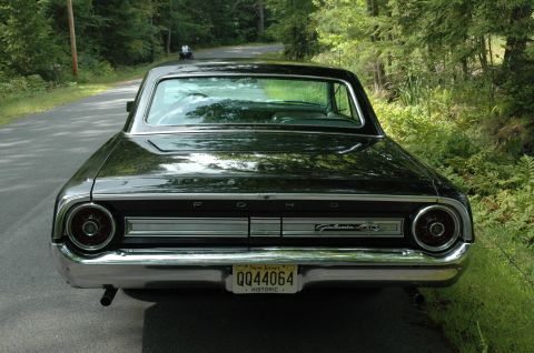 1964 Ford Galaxie - Rear view of a black 1964 Ford Galaxie parked on a tree-lined road.
