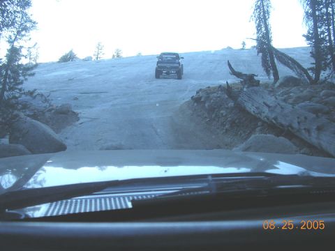 1994 Ford Bronco - Two vehicles navigate a challenging off-road course on a sunny day.