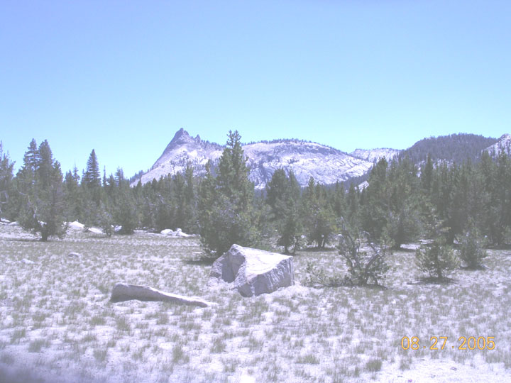 Mountain landscape with pine trees, rocks, and a clear blue sky. Date stamp reads 08.27.2005