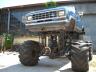 1990 Ford Bronco - A heavily modified truck with oversized tires and a raised chassis is shown from the front.
