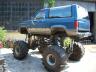 1990 Ford Bronco - This heavily modified SUV features oversized tires and a significant suspension lift, obscuring its original model year.