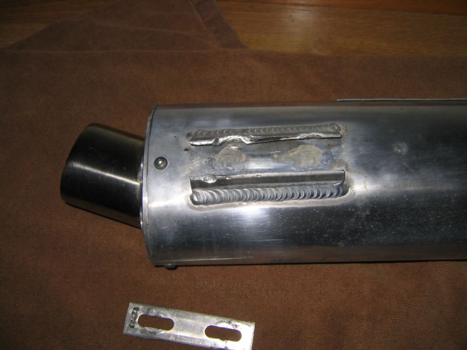 Aluminum motorcycle exhaust canister with TIG-welded mounting slots and loose bracket