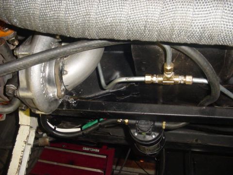1995 Ford Mustang - Close-up view of a turbocharger and its associated plumbing, including hoses and brass fittings.