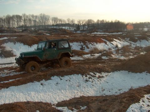 1996 Ford F-250 - Jeep Wrangler navigating a challenging off-road course with mud and snow.