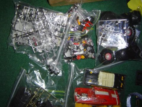 1979 Ford Bronco - Various model car parts are organized in plastic bags, alongside partially assembled model cars.