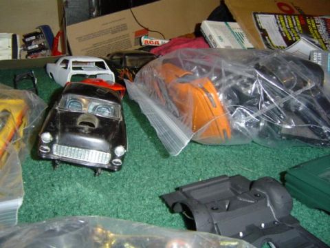 1979 Ford Bronco - Various model car kits and unassembled parts are spread across a green carpeted surface.