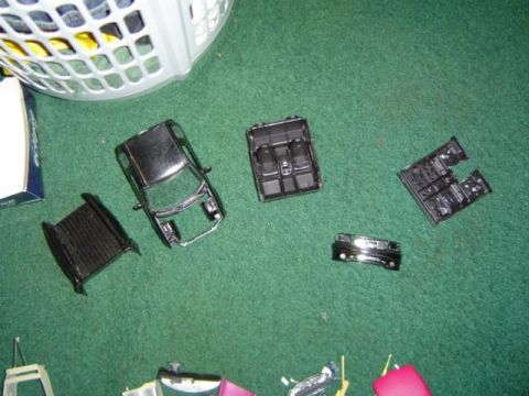 1979 Ford Bronco - Model car parts, including the body and interior, are laid out on a green surface.