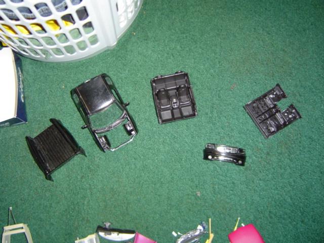 model car body, interior, and chassis parts scattered on green carpet