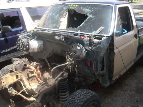 1990 Ford Bronco - This 1990 Ford Bronco is missing its hood, fenders, and grille, with a shattered windshield.