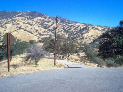 1988 Ford Bronco - A desolate road winds through a dry, mountainous landscape on a clear day.