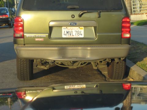 1990 Ford Bronco - Rear view of a green Ford Explorer Sport SUV with California plate 4MVL784, its rear axle and suspension visible beneath the bumper.