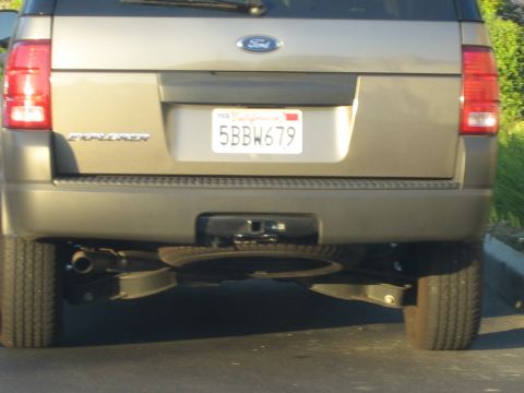 1990 Ford Bronco - Rear view of a tan Ford Explorer SUV with California plate 5BBW679, showing a trailer hitch and exhaust beneath the bumper.